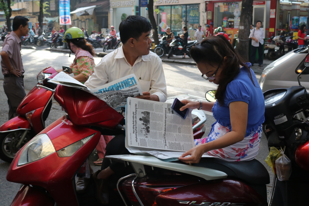 Những phụ huynh đọc báo trong thời gian chờ đợi.