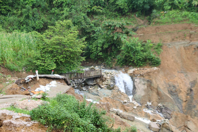 Con đường bê tông và chiếc cầu nối vào bản Sáng Tùng cũng bị dòng nước lũ và đất đá làm hư hỏng nghiêm trọng