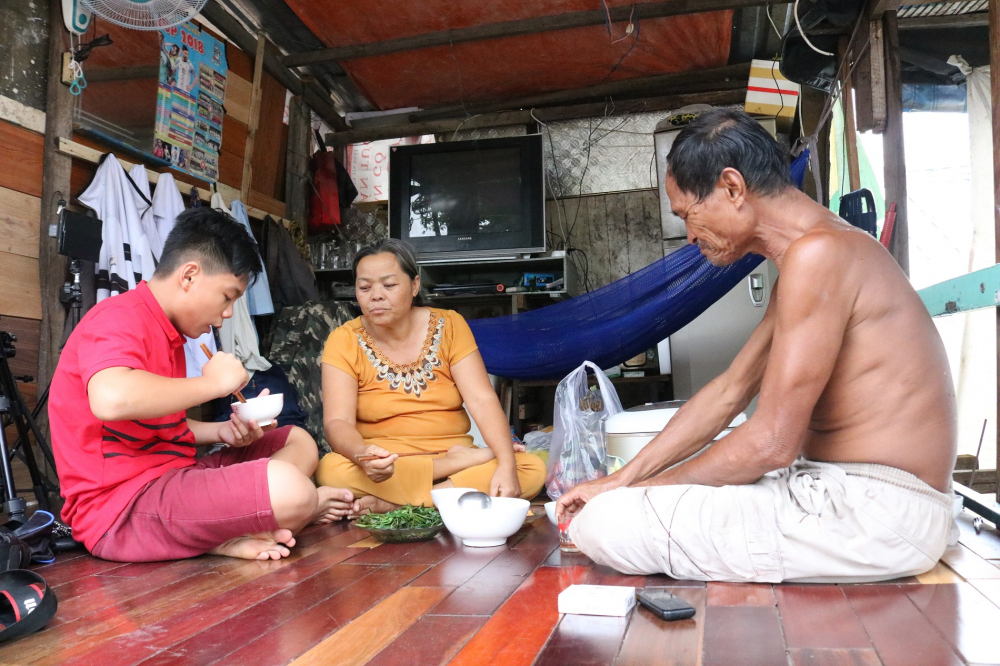 Vợ chồng ông Ba Chúc cùng đứa cháu ngoại sum vầy bên mâm cơm trưa. (Ảnh: Huy Hoàng)