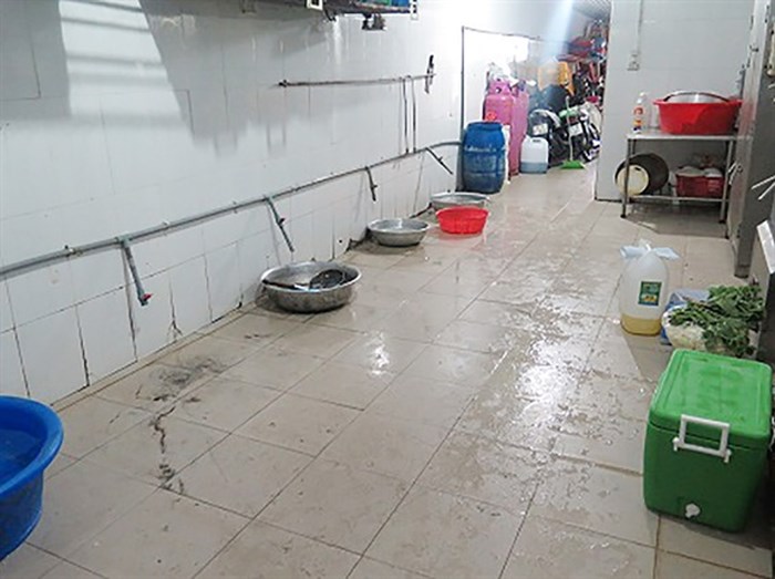 Khu vực chế biến thức ăn rác và nước ứ đọng trên sàn nhà. (Ảnh: BQL ATTP TP.HCM)