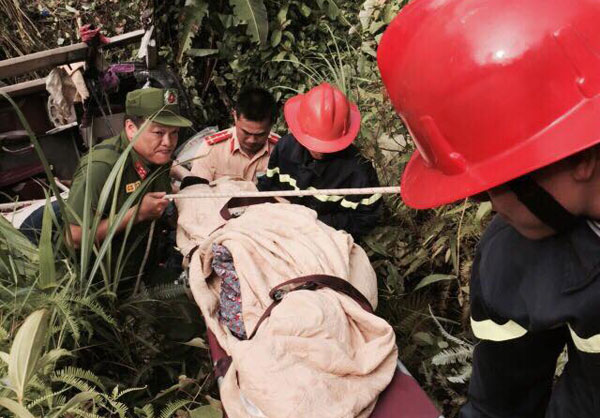 Lực lượng cứu hộ đưa nạn nhân gặp nạn vụ xe khách giường nằm lao vực lên trên - Ảnh: Vũ Tiệp