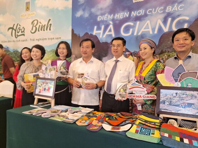 Các đại biểu Tây Bắc và TP.HCM chụp ảnh cùng nhau tại bàn quảng bá sản phẩm du lịch Hà Giang.