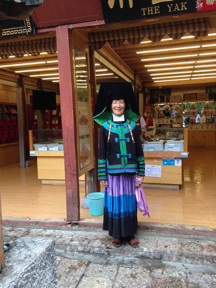 Một phụ nữ dân tộc Nanxi tại Lệ Giang cổ trấn tạo dáng cho du khách chụp ảnh.