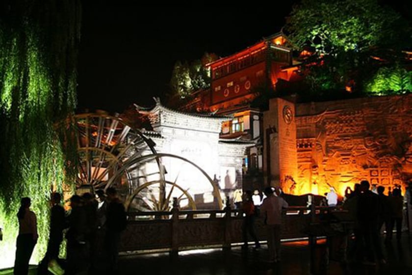 Biểu tượng Bánh xe gỗ quay guồng nước là một điểm check-in nổi tiếng thu hút du khách dạo chơi, tìm hiểu cuộc sống về đêm tại lối vào quảng trường trung tâm Lệ Giang cổ trấn.