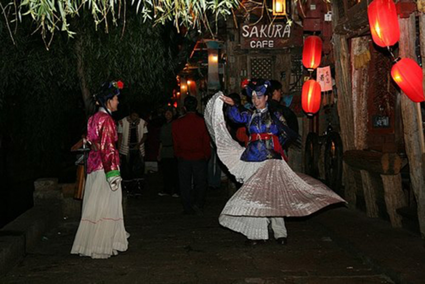 Một màn trình diễn trước cửa quán, chào đón du khách khám phá cuộc sống về đêm và nét văn hóa ẩm thực của Lệ Giang cổ trấn.