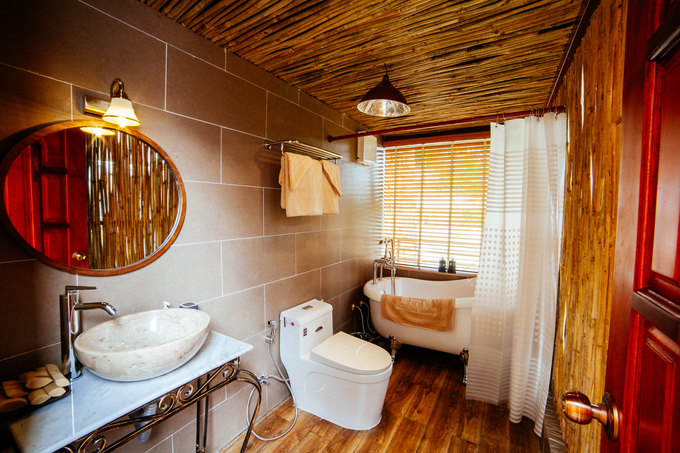 Diện tích nhà vệ sinh rộng rãi với nội thất bằng gỗ trang trọng và bồn tắm lớn tiện nghi, hiện đại