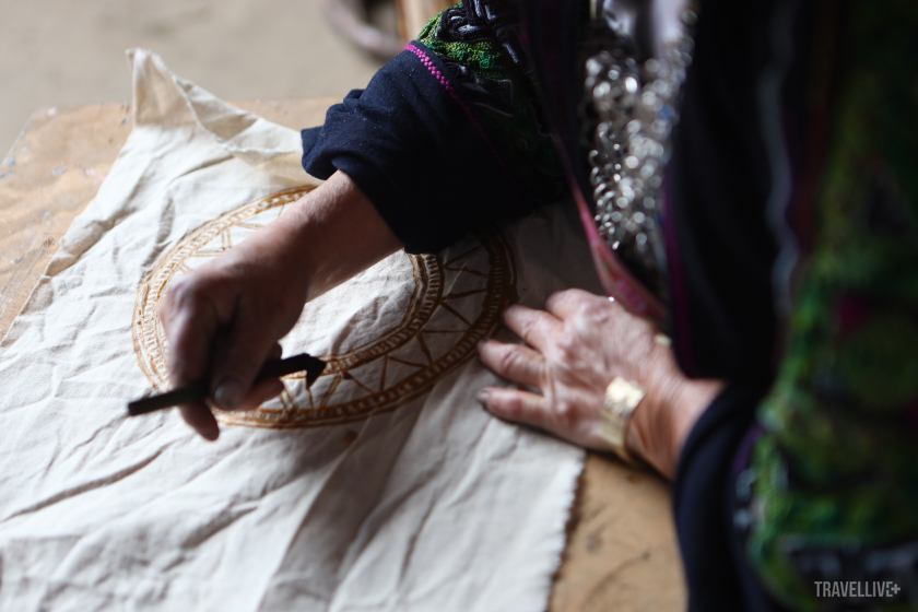 Những nghệ nhân người Mông vẽ sáp ong lên vải.