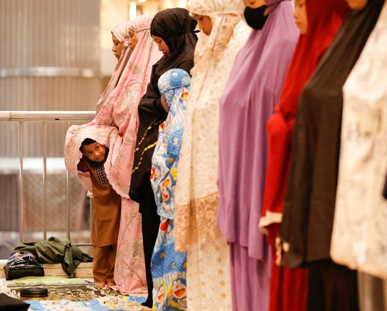 Một cậu bé lén nhìn những người phụ nữ Hồi giáo trong buổi cầu nguyện ở Đại Thánh đường Istiqlal ở Jarkarta, Indonesia vào ngày 22 tháng 03.