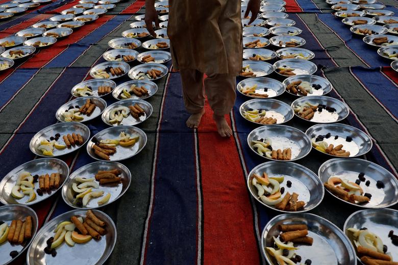 Một người đàn ông đang đi kiểm tra các khay trức ăn trước ifta, hay còn gọi là bữa sáng trong tháng ăn chay Ramadan, ở Karachi, Pakistan ngày 22 tháng 03.