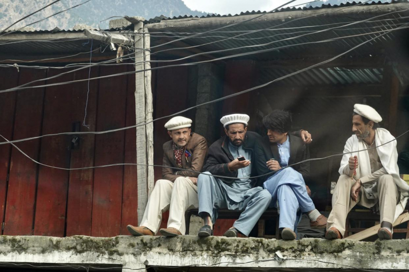 Những người đàn ông ngồi thong thả trước hiên nhà ở Pakistan.
