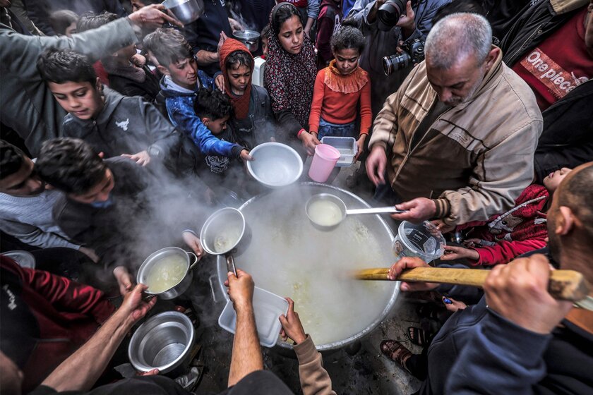 Người Palestin Walid al-Hattab phát súp từ một cái nồi lớn cho những thanh niên nghèo khó ăn sáng vào ngày thứ hai của tháng Ramadan, tại Thành phố Gaza