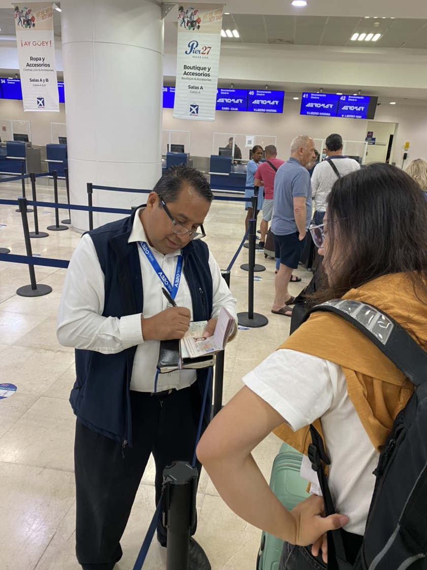Nhân viên hàng không đang bán tourist card của Cuba ở sân bay Mexico trước khi bay qua Cuba.