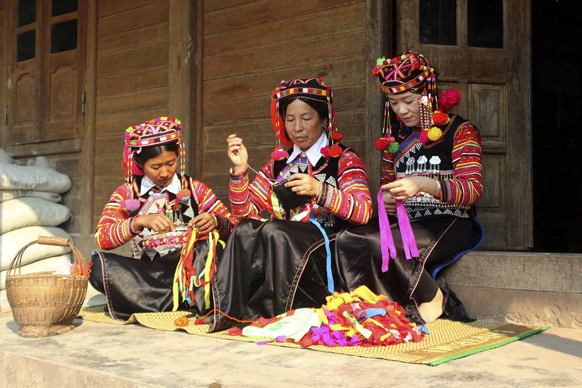 Những người phụ nữ Hà Nhì trong trang phục truyền thống ngồi thêu vật dụng