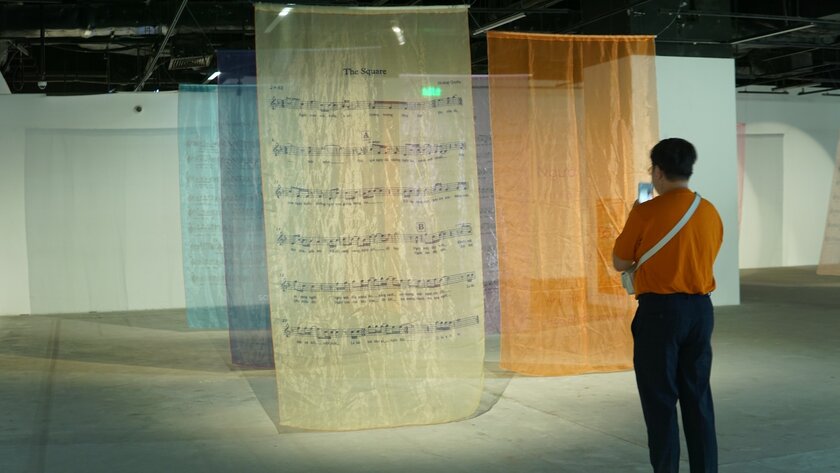 Một tác phẩm sắp đặt gồm bản nhạc của Hoàng Quyên đặt trong không gian triển lãm