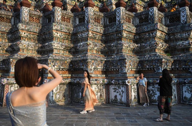 Khách Trung Quốc trong trang phục truyền thống Thái Lan chụp hình tại đền Wat Arun