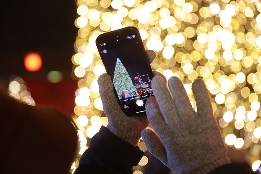 Chụp ảnh cây thông Noel được chiếu sáng vào ngày đầu tiên của phiên chợ Giáng sinh hàng năm tại Tòa thị chính Red, ở Berlin, Đức
