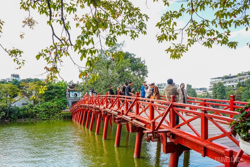 Cầu Thê Húc màu đỏ nổi bật giữa dòng hồ xanh trong.