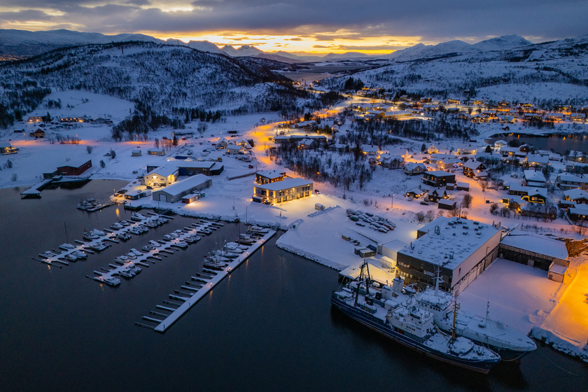 Một góc của thành phố Tromso nhìn từ trên cao với những mái nhà phủ trắng tuyết bên bờ biển.
