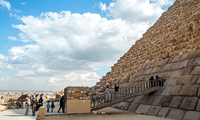 Du khách tạo dáng chụp ảnh dưới chân kim tự tháp. Ảnh: Khaled Desouki/AFP/Getty Images
