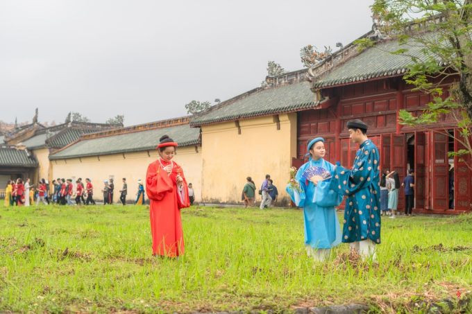 Nhóm bạn trẻ mặc áo dài cổ phục chụp ảnh trước Trường Lang trong Hoàng cung Huế.