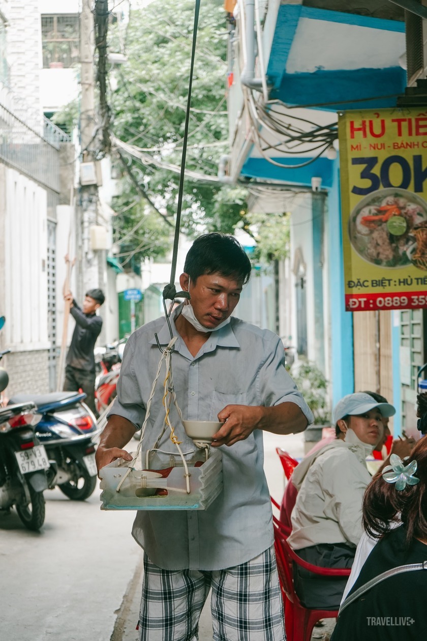 Những tô hủ tiếu được thả xuống, bên dưới sẽ có người lấy hủ tiếu ra đưa đến tay khách.