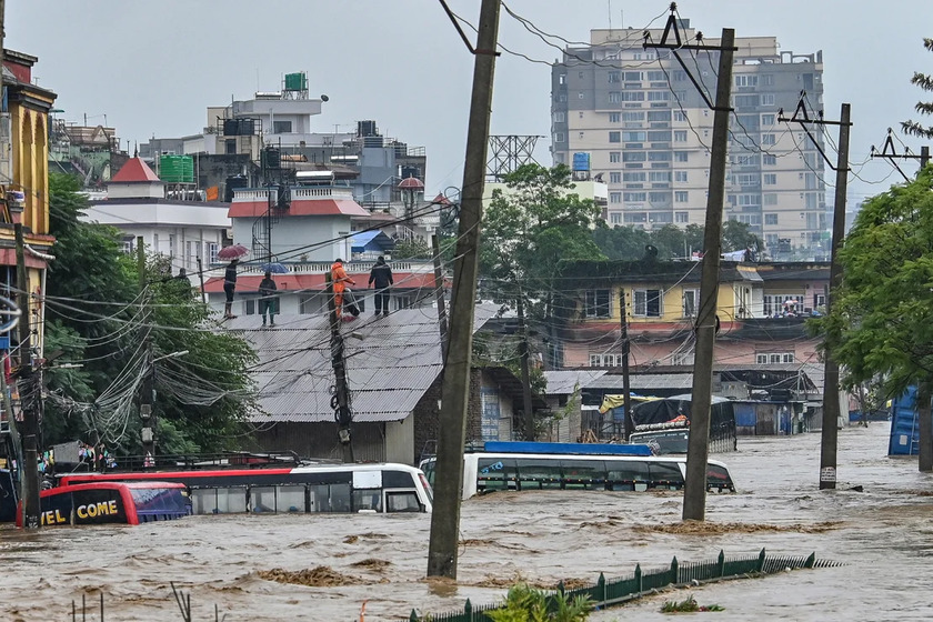 Nước lũ dâng cao khiến nhiều người dân phải trèo lên mái nhà chờ cứu hộ