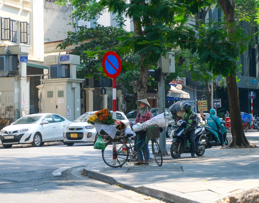 Người gánh hàng rong tranh thủ dành ít phút nghỉ ngơi ngay tại ngã tư đường