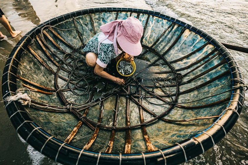 Người phụ nữ ngồi gỡ cá