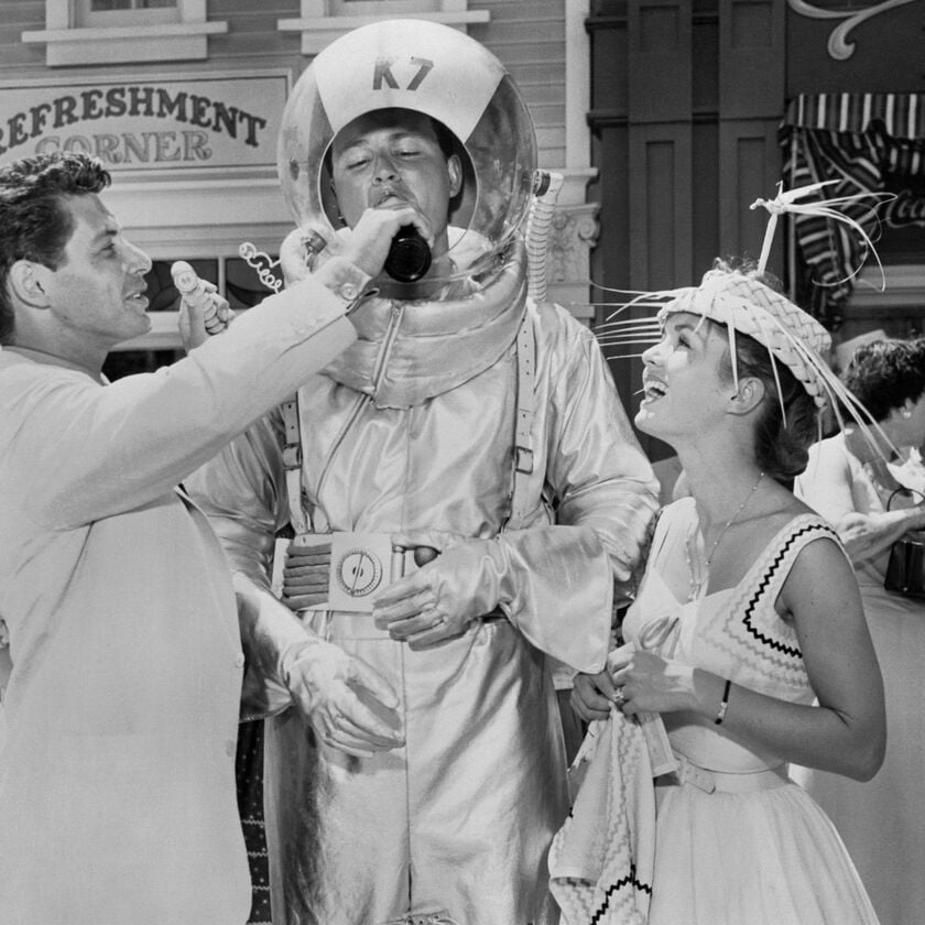 Eddie Fisher, ca sĩ kiêm diễn viên nổi tiếng - đồng dẫn chương trình khai trương - rót đồ uống cho Don MacDonald khi nữ diễn viên Debbie Reynolds đứng cạnh theo dõi. Fisher và Reynolds đã kết hôn trong năm đó