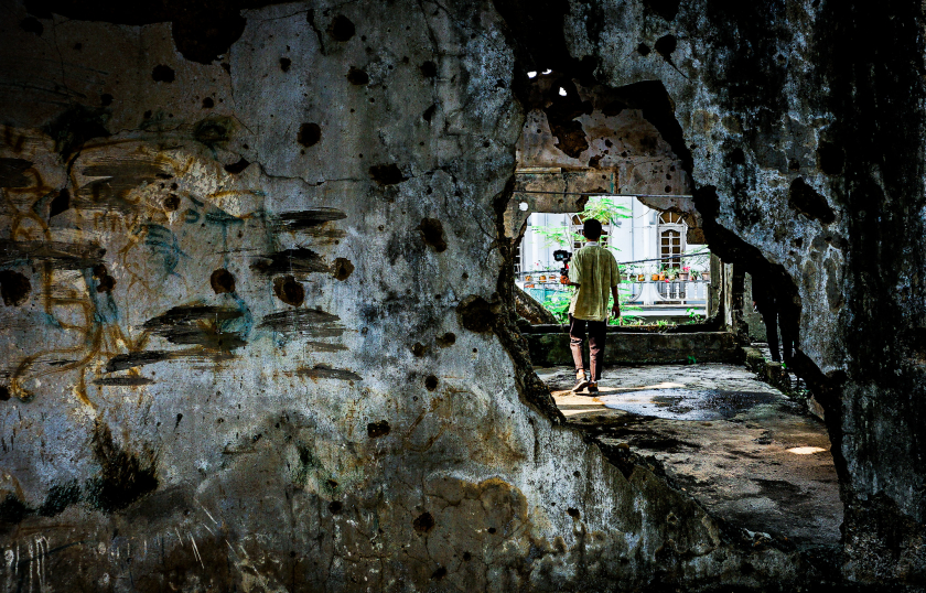 Những lỗ bom đạn chằng chịt trên tường làm sống dậy sự đau thương của chiến tranh.