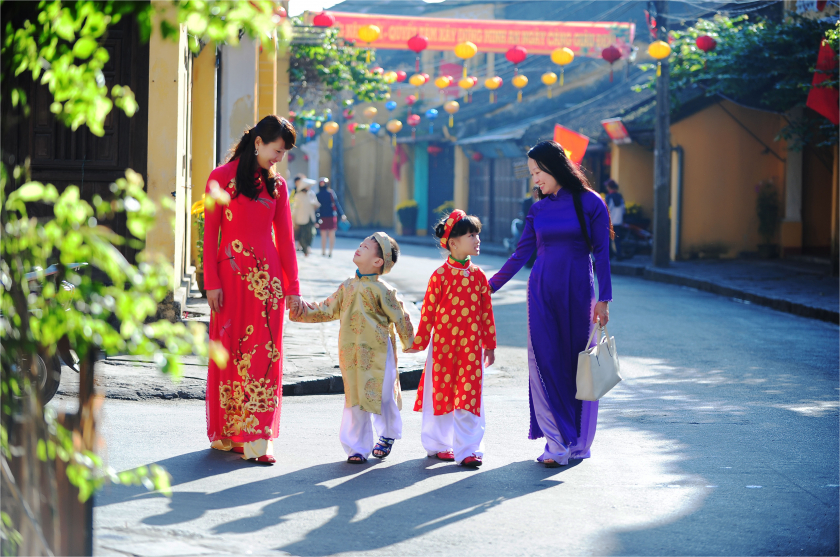 Những em bé cùng mẹ đi chuẩn bị Tết trong trang phục truyền thống.