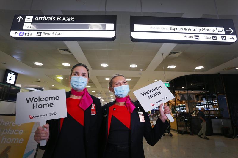 Nhân viên của hãng hàng không Qantas chào mừng những người từ nước ngoài trở về với tấm bảng: 
