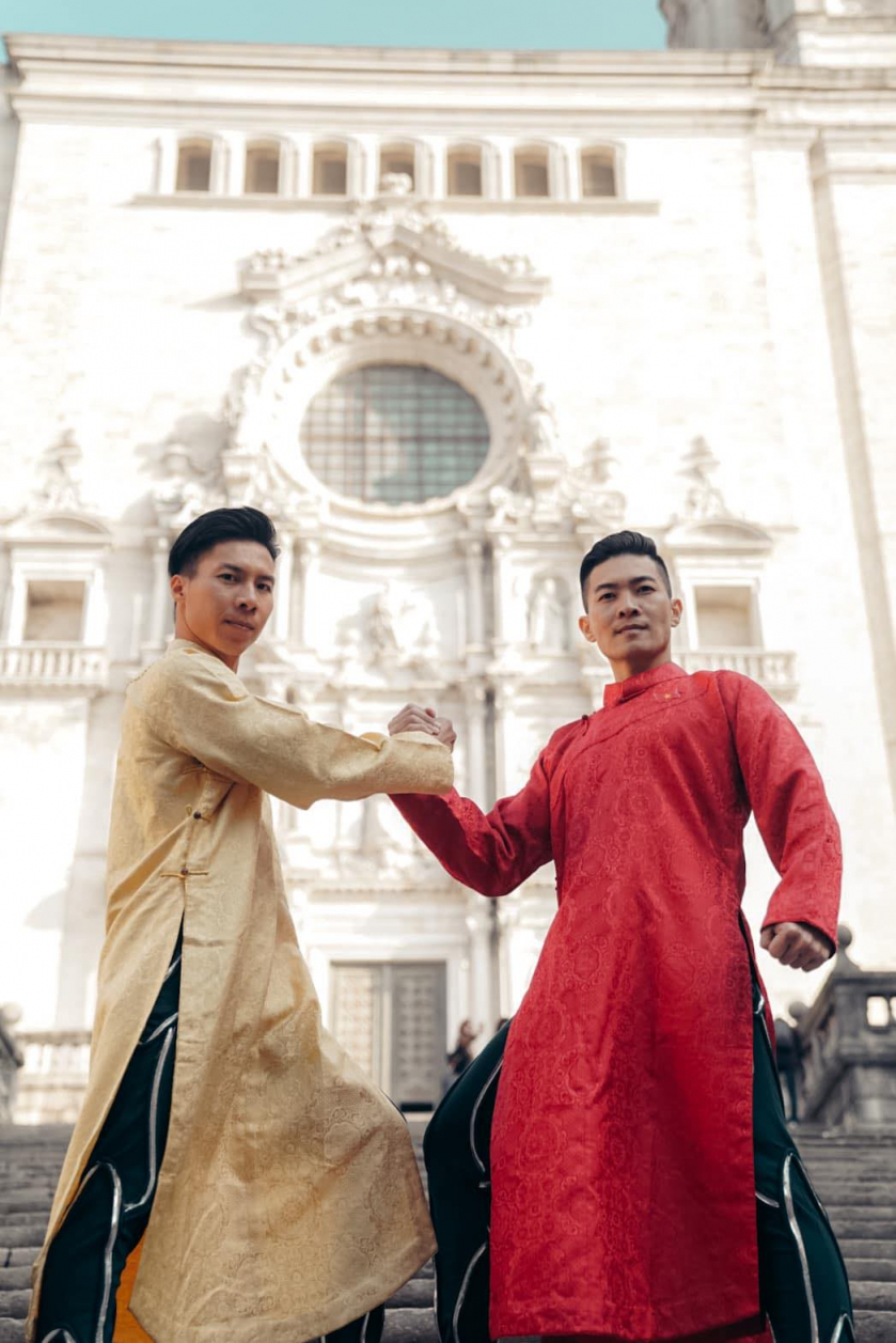 Anh em nghệ sĩ xiếc Quốc Cơ - Quốc Nghiệp trong trang phục áo dài dân tộc trước nhà thờ Girona - Ảnh: HAI VU NGUYEN