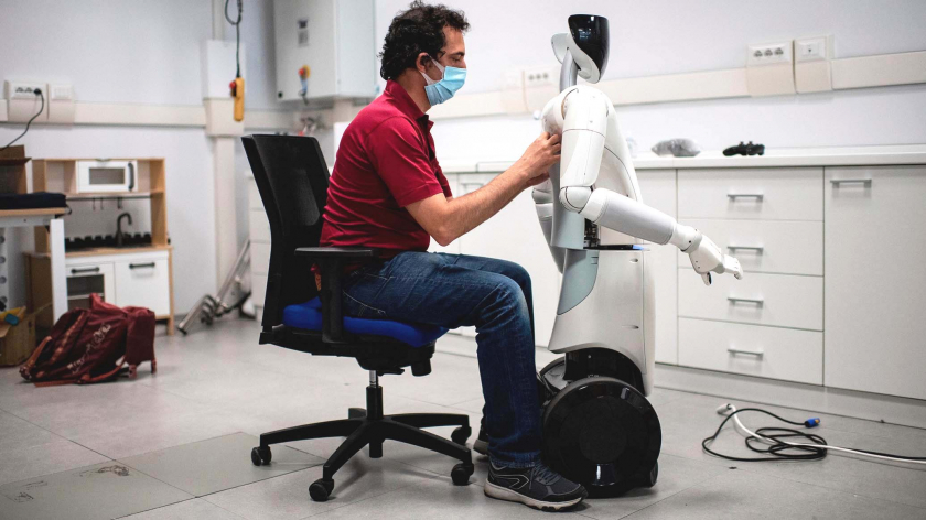 Một kỹ sư đang kiểm tra robot tại Viện Công nghệ Ý ở Genoa vào đầu năm 2020, viện nghiên cứu này có kế hoạch tạo ra robot để giúp đỡ khách du lịch tại các ga tàu và sân bay. - Ảnh: Getty Images/Dan Kitwood