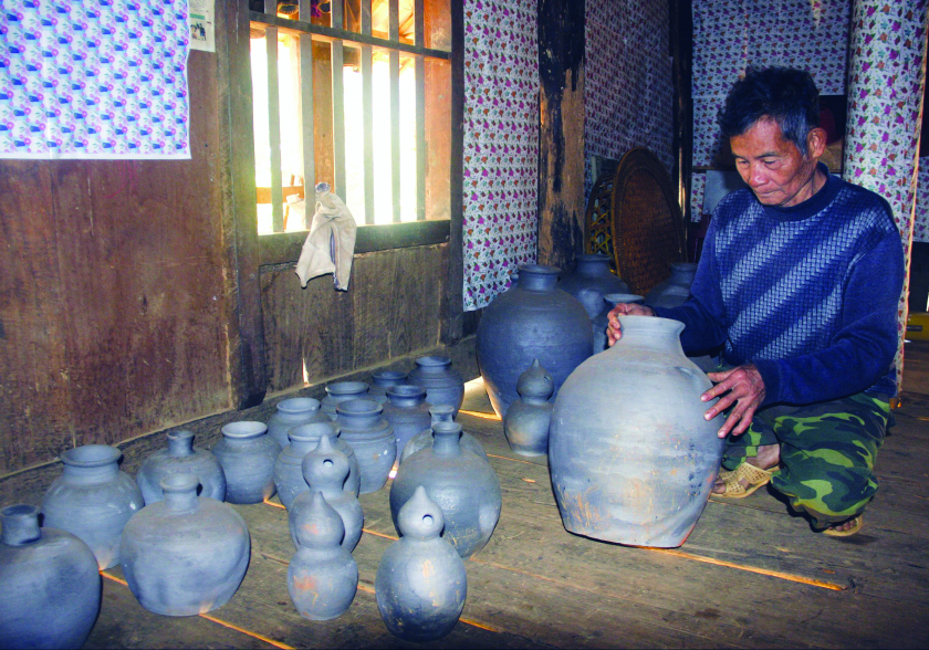 Ông Hoàng Văn Nam kiểm tra các sản phẩm gốm truyền thống.