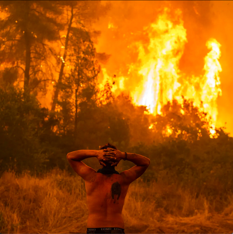 Người đàn ông đứng nhìn trước ngọn lửa đang đến gần làng Pefki, đảo Evia. (Ảnh: AFP/Getty Images)