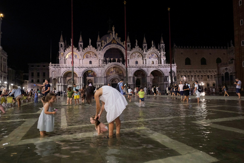 Người dân thích thú đi dạo và vui chơi ở Quảng trường San Marco khi ngập nước - Ảnh: Reuters/Manuel Silvestri