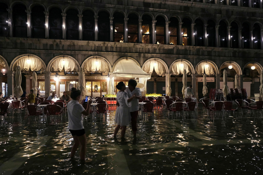 Một cặp đôi khiêu vũ trên Quảng trường San Marco khi nước mới dâng ở Venice ngày 8/8 - Ảnh: Reuters/Manuel Silvestri