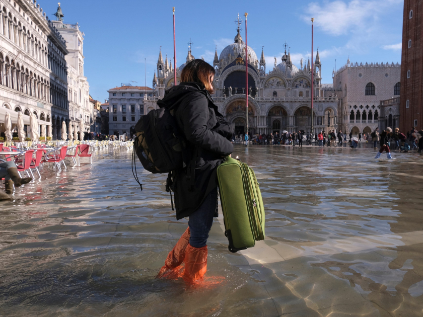 Một cô gái xách vali băng qua Quảng trường San Marco - Ảnh: Reuters/Manuel Silvestri
