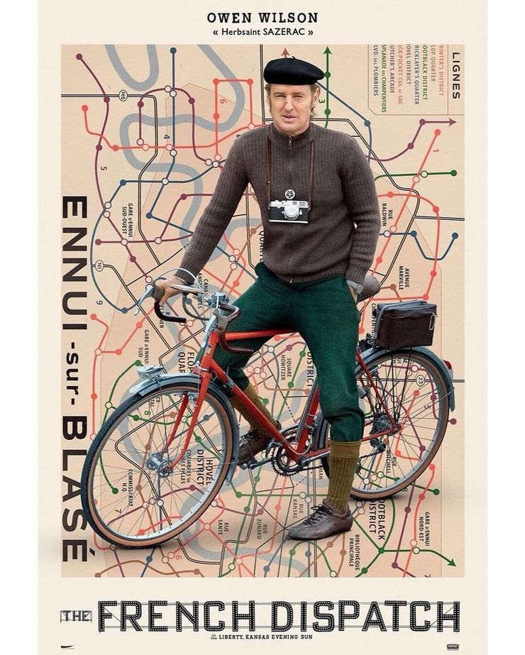 Owen Wilson là một tay đua xe đạp kiêm phóng viên Herbsaint Sazerac, sau lưng ông là bản đồ Ennui-sur-Blasé với tuyến đường đạp xe được tô màu.