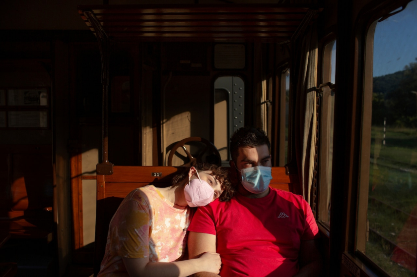 Một cặp đôi ngắm cảnh hoàng hôn trên toa tàu