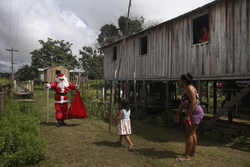 Ông già Noel ghé thăm những người sống trong rừng rậm ven biển để tặng quà cho trẻ em, ở lưu vực sông Amazon vùng Careiro de Varzea, Brazil - Ảnh: Edmar Barros/AP