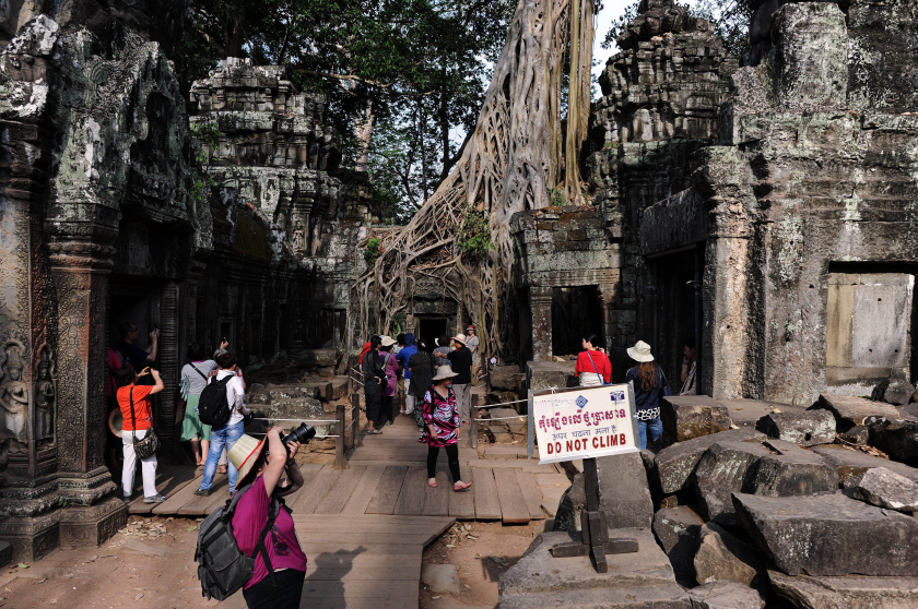 Du khách tham quan đền Ta Phrom, một phần của Angkor Wat. (Ảnh: AFP/TTXVN)