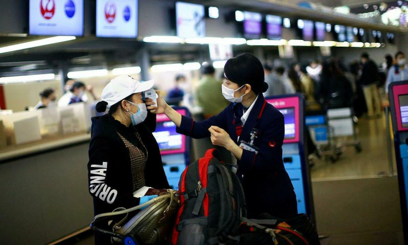 Du khách nước ngoài nhập cảnh Nhật Bản đều phải đeo khẩu trang và có bảo hiểm. Ảnh: Reuters