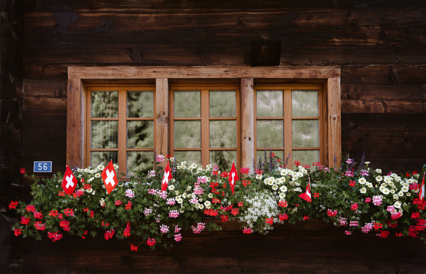 Cờ và hoa bên khung cửa sổ nhỏ đầy thơ mộng