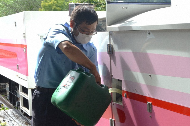Một nhân viên của Công ty Đường sắt Amaterasu tiếp nhiên liệu cho chuyến tàu đầu tiên trong ngày bằng nhiên liệu sinh học ở Takachiho, tỉnh Miyazaki. Ảnh: Isao Araki