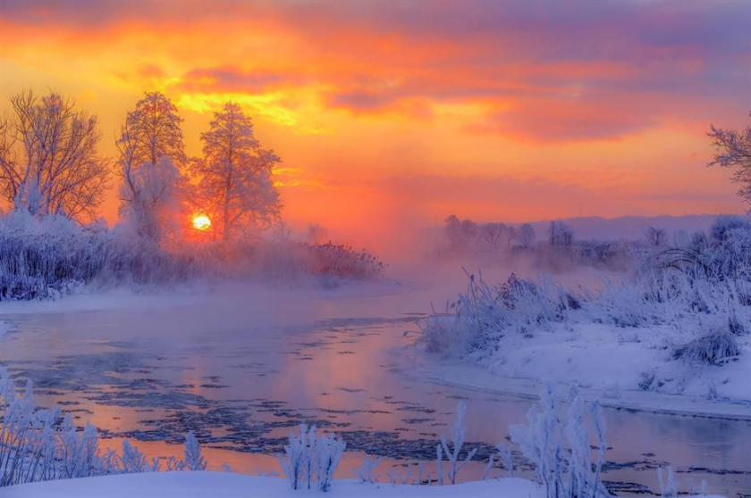 Bình minh mùa đông băng giá trên sông Gwda, Pila, Ba Lan: Vào mùa đông, không có cảnh nào đẹp hơn một buổi sáng trong trẻo, đầy sương giá. Nhiếp ảnh gia Krzysztof Tollas đã chụp được cảnh bình minh màu đỏ cam nổi bật trên sông Gwda ở tây bắc Ba Lan. Cảnh tượng trở nên diệu kỳ hơn bởi những làn sương mù bốc lên trên mặt nước và những cây tuyết phủ ở phía xa