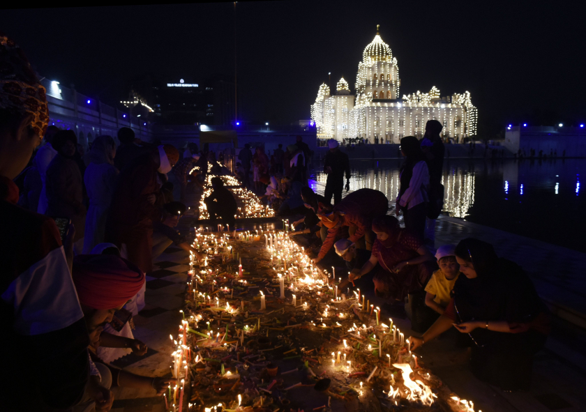 Các tín đồ đạo Sikh thắp nến lúc hoàng hôn trong Lễ hội Diwali tại ngôi đền Gurudwara Bangla Sahib được chiếu sáng ở New Delhi