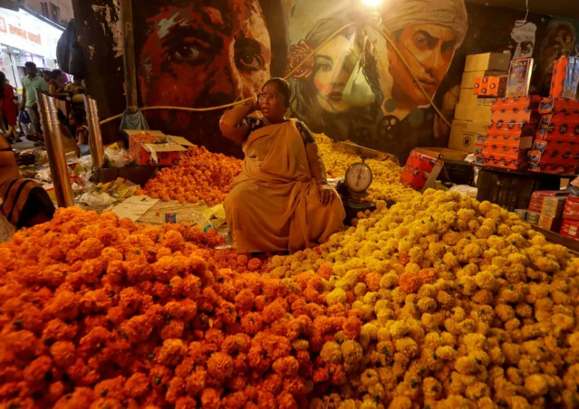 Người phụ nữ bán hoa đứng đợi khách hàng ở chợ, trước Diwali ở Mumbai