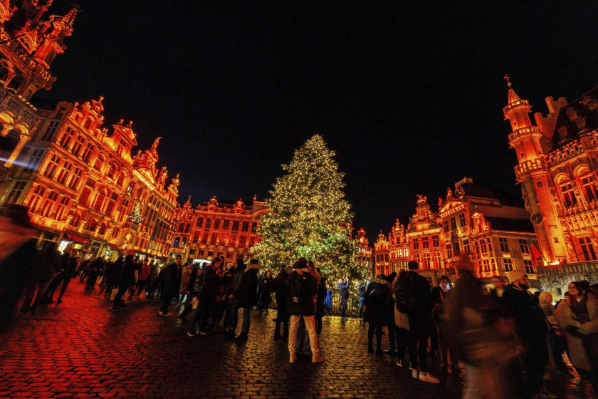 Du khách đứng trước cây thông Noel được chiếu sáng tại Winter Wonder và Chợ Giáng sinh trên Grand Place ở Brussels, Bỉ